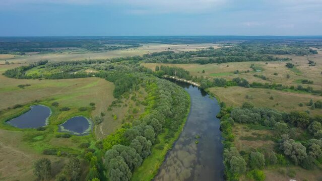 Beautiful aerial view video from a drone of Ukrainian nature - Seim river, summer sunny day on the river with trees and open spaces.