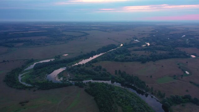 Beautiful aerial view video from a drone of Ukrainian nature - Seim river, morning sun in the mist on the river with trees and open spaces.