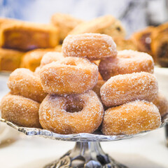 Freshly cooked doughnuts on silver stand  