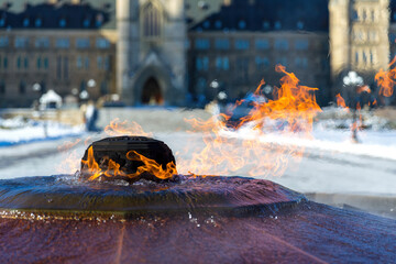 The eternal flame burns outside of a snow covered Canadian Parliament building in Ottawa, Ontario. It commemorates the 100th anniversary of the Confederation and the fountain never freezes