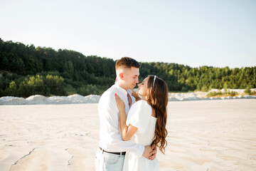Young couple hugging on a sandy beach on a sunny day