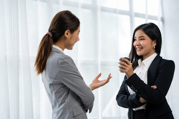 Two Asian businesswoman colleagues drink coffee. and discuss new marketing business strategy projects Meeting to meet professional investors at work. and business finance and accounting concepts.