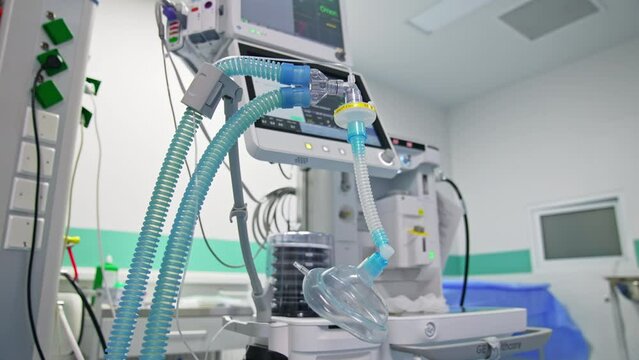 Blue tubes with oxygen mask for a patient breathing during operation. Modern surgery equipment at backdrop.