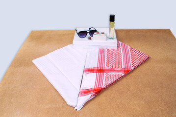 Saudi Arabian men wearing style accessories red white headscarf shemagh sunglasses perfume stone ring cufflinks decorated on wooden sheet - Powered by Adobe