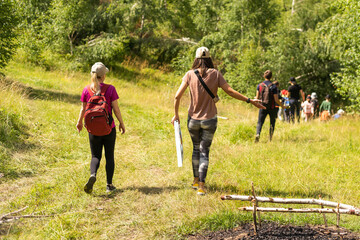 Obraz premium Group of friends trekking with backpacks walking in the forest.