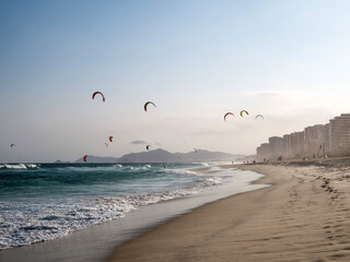 Kitesurfers catch the evening breeze on the Barra da Tijuca beach in Rio