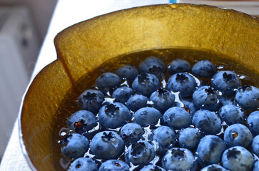 Blue berries on a golden plate. A healthy dessert. Ripe blueberries 