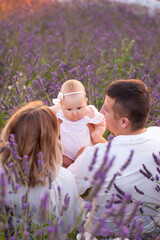 Beautiful young family on purple flower lavender field. Family vacation