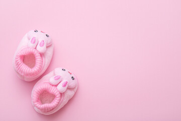 booties in the shape of a hare on a pink background with copy space
