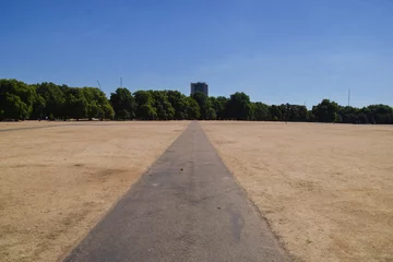 Fotobehang A parched Hyde Park on a scorching day as heatwaves and drought caused by climate change continue in the UK © VV Shots