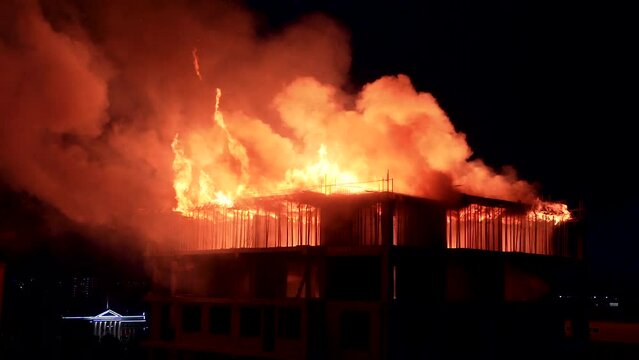 Slow motion burning fire flame on residential building roof at night