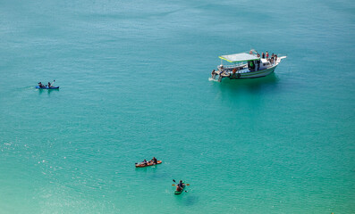 people kayaking at tropical turquoise ocean. High angle view