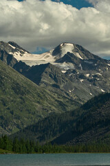 The smooth surface of a glacial lake at the foot of the Altai Mountains in the Katunsky Reserve