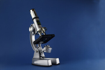 microscope isolated on blue background. Image contains copy space