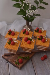 Trifle with raspberries, with a bouquet of flowers and a blurred background.
