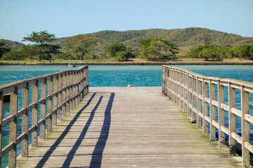 Obraz premium Perspective view of a wooden pier on tropical sea bay at sunny day