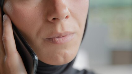 Close-up young unrecognizable arab woman in hijab talks on mobile phone confident businesswoman answering business call communicates with client remote using smartphone speaks with friend on telephone