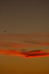 Plane silhouette over the clouds in sunset