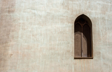 Concrete gray wall with arabic window covered with rusty fine mesh