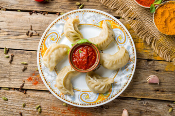 Indian food Momo with chicken and tomato sauce top view on wooden table