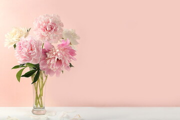 Home interior with decor elements, beautiful spring peony branches in a vase on a light background, abstract flower composition, still life with place for text, flower card for birthday
