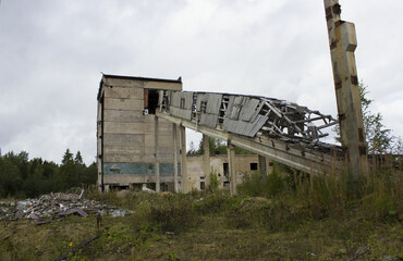 Fototapeta na wymiar abandoned ruined building. concrete walls with broken windows and a lift, industrial buildings. victory of nature over industry and progress, devastation