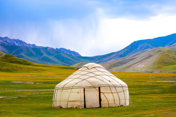 Yurt. National old house of the peoples of Kyrgyzstan and Asian countries. national housing. Yurts on the background of green meadows and highlands. Yurt camp for tourists in the mountains.