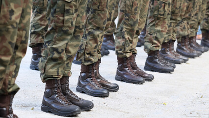 Kamasze wojskowe na nogach żołnierza.  Kamuflaż. - obrazy, fototapety, plakaty
