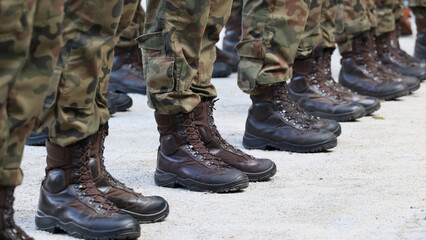Kamasze wojskowe na nogach żołnierza.  Kamuflaż. - obrazy, fototapety, plakaty