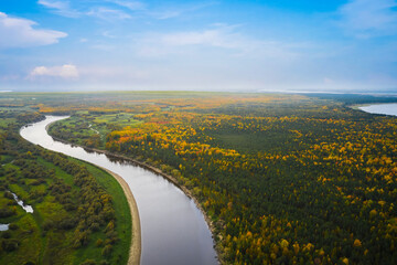 Aerial view of the autumn forest with winding riverbeds and many small lakes. Swampy area. Shooting from a drone.