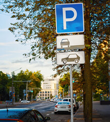 Cars in parking zone at roadside in the city. Parking lot sign, one free parking space, cars in...