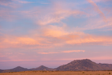 Fototapeta na wymiar Colorful sunrise over distant mountains and dry plains