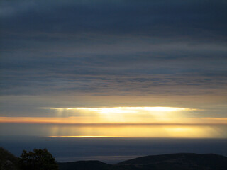 Fototapeta na wymiar Rays of sun breaks through a gap in the cloud
