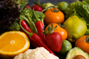 Different vegetables and fruits on a dark background