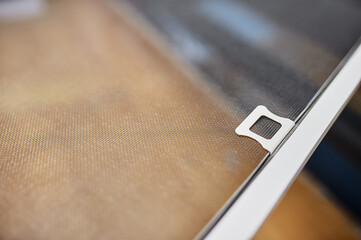 Fixing the mosquito net close-up for removing and installing on plastic Windows.