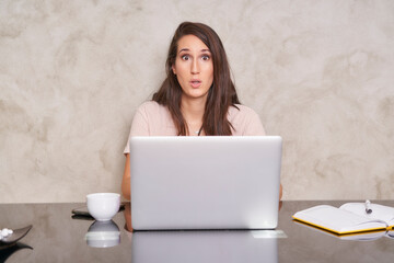 woman in front of laptop with a surprised face