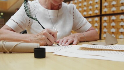 4K. An elderly woman writes a letter in the library