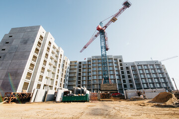 Construction crane at a city construction site on a background of blue sky