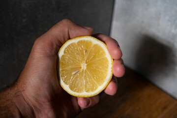 lemon in hand on wooden table