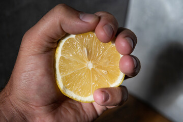 lemon in hand on wooden table