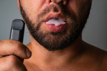 a man exhaling vapor from an electronic cigarette