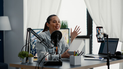 Digital content creator unpacking and reviewing electronic product to audience. Famous social media influencer doing promotional video for smartphone while presenting it to public in home studio.