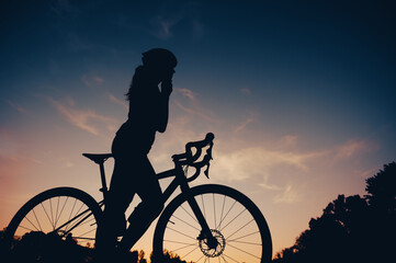 Obraz premium Sporty woman riding a bicycle in the nature while wearing a protective gear