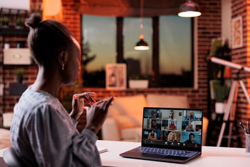 Corporate worker chatting with remote team on videocall using laptop, back view. Company colleagues discussing business on teleconference, freelancing and telework concept