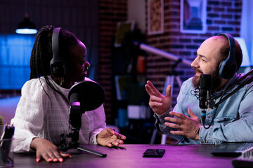 Diverse team of influencers creating channel content on podcast, filming vlog for social media....