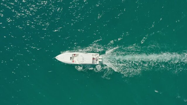 Aerial view of a speed boat sailing on the Indian Ocean. The shot is parallel to the water and the yacht is sailing across the sea. High quality 4k footage