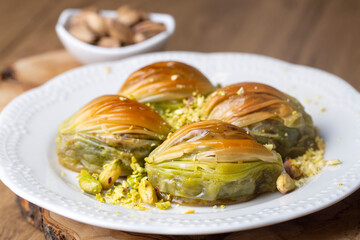 Turkish Midye Baklava ( Mussel Shape Baklava ) with green pistachio Powder and Butter Cream. Conceptual of Islamic Feasts.