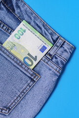 In the back pocket of blue jeans, 100 euro banknotes are folded in half - vacation pay, trip abroad on a business trip, immigration, salary