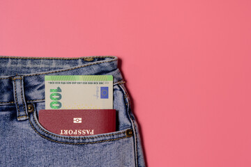Several banknotes look like unnumbered euros and a red foreign passport in the front pocket of jeans - vacation, trip abroad on a business trip, immigration