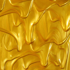 Glittering shiny metallic gold paint flowing and dripping downward making a golden background.
